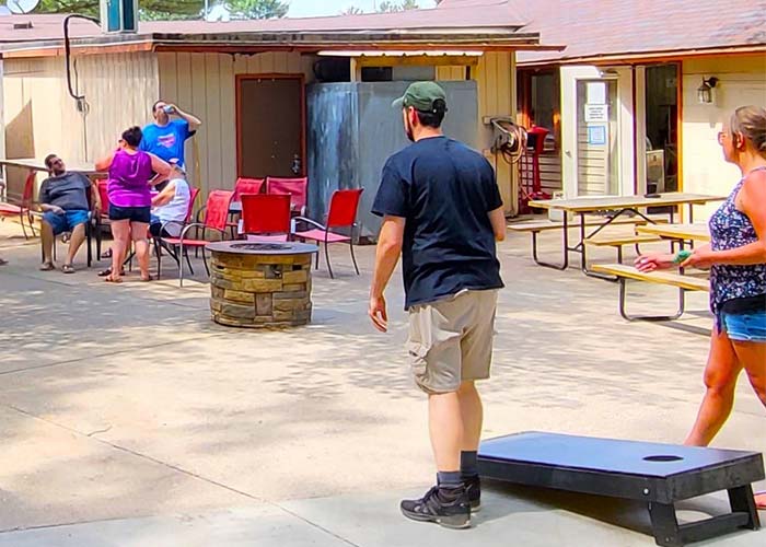 Players competing at the Pineland Grille cornhole bags tournament toss bean bags.